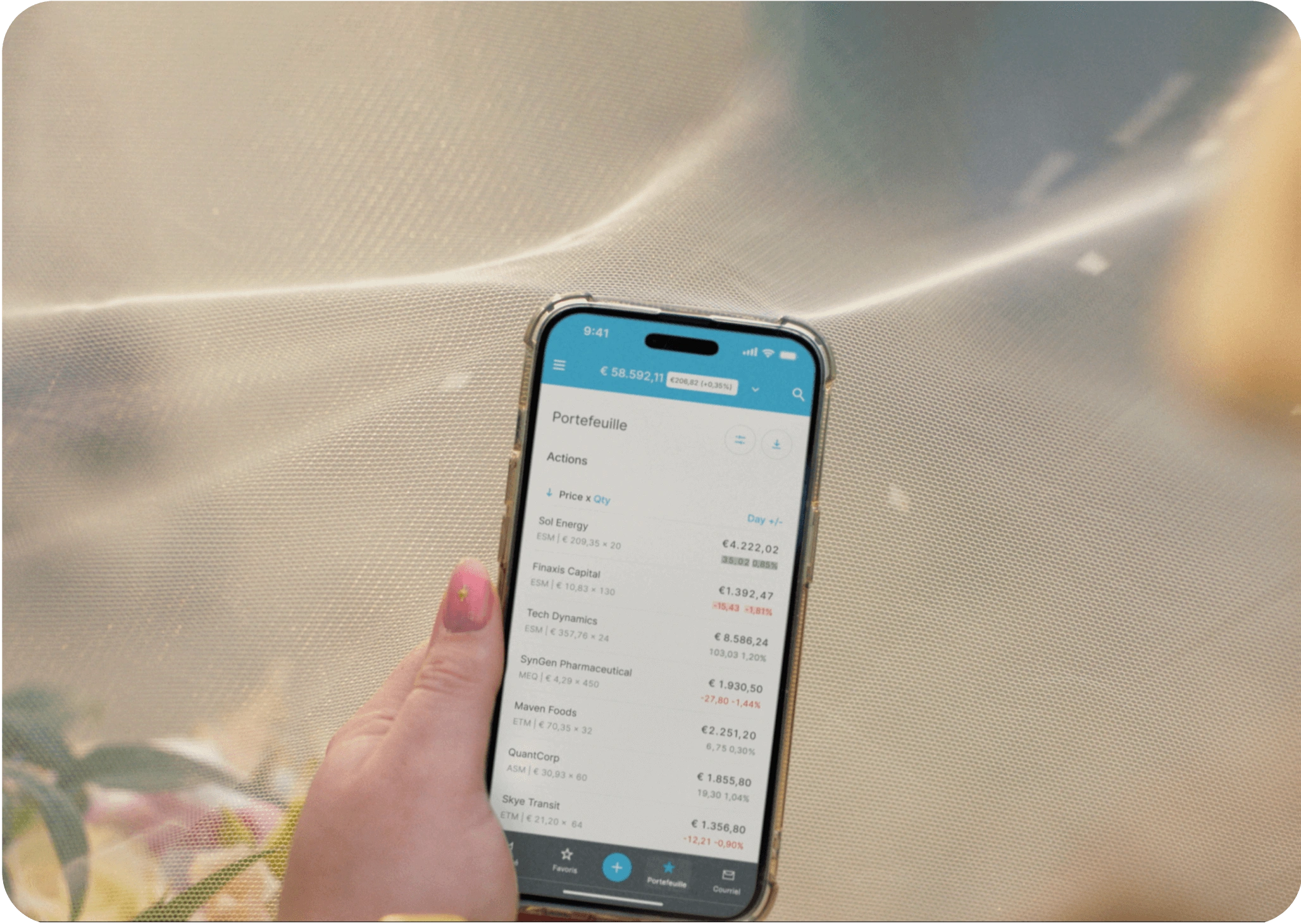 Mano sosteniendo smartphone mostrando pantalla de cartera de la app EXDEGIRO con acciones y precios.